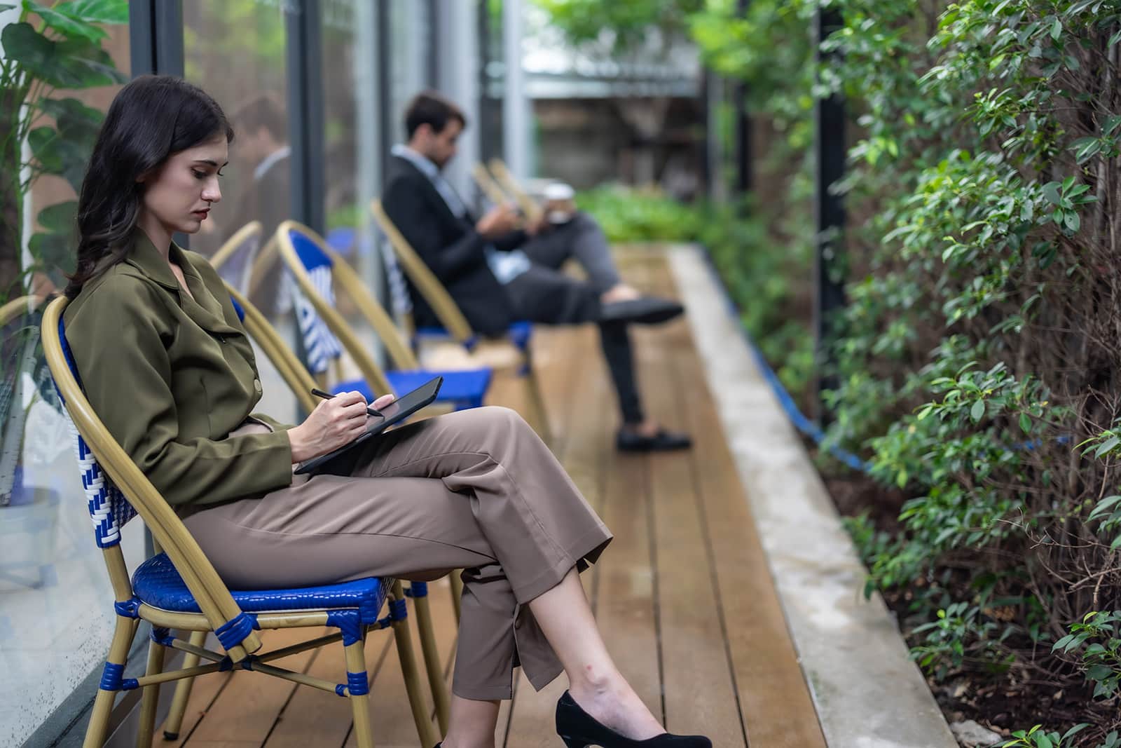 Person sitting on a deck surrounded by plants